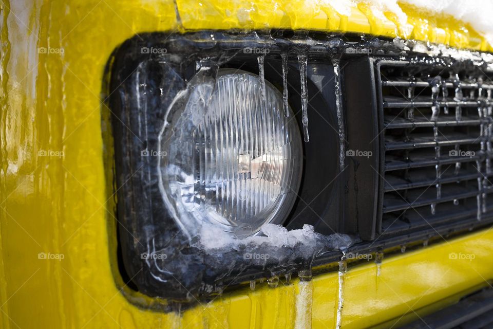 car light covered with an icicles and frozen