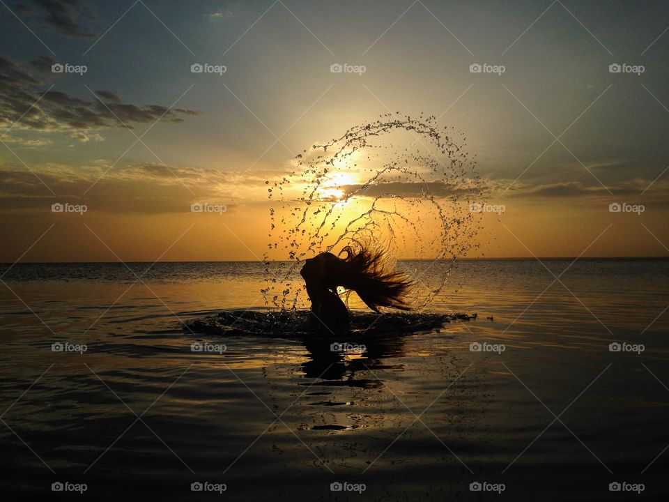 woman dipping into the river at sunset in Amazon, Brazil.