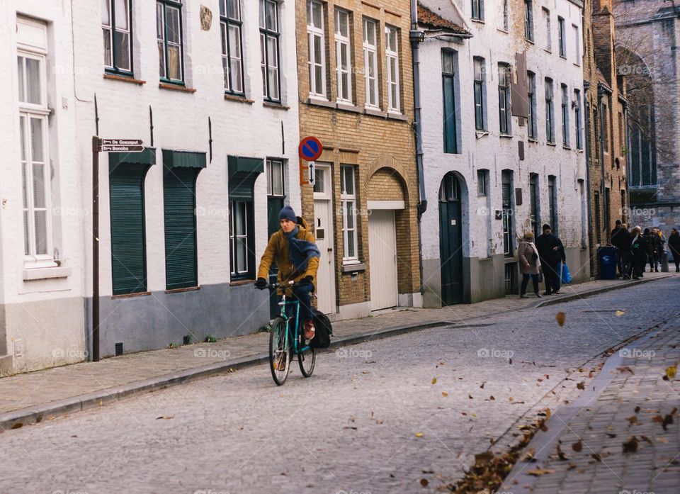 Young man, riding his bicycle to work, on a cold autumn morning.