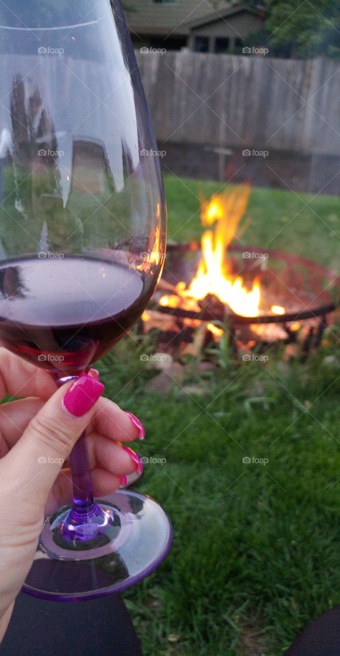 Sipping red wine at the campfire