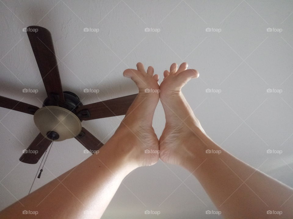 two bare feet in the air posing with and arched sole and fanned toes.