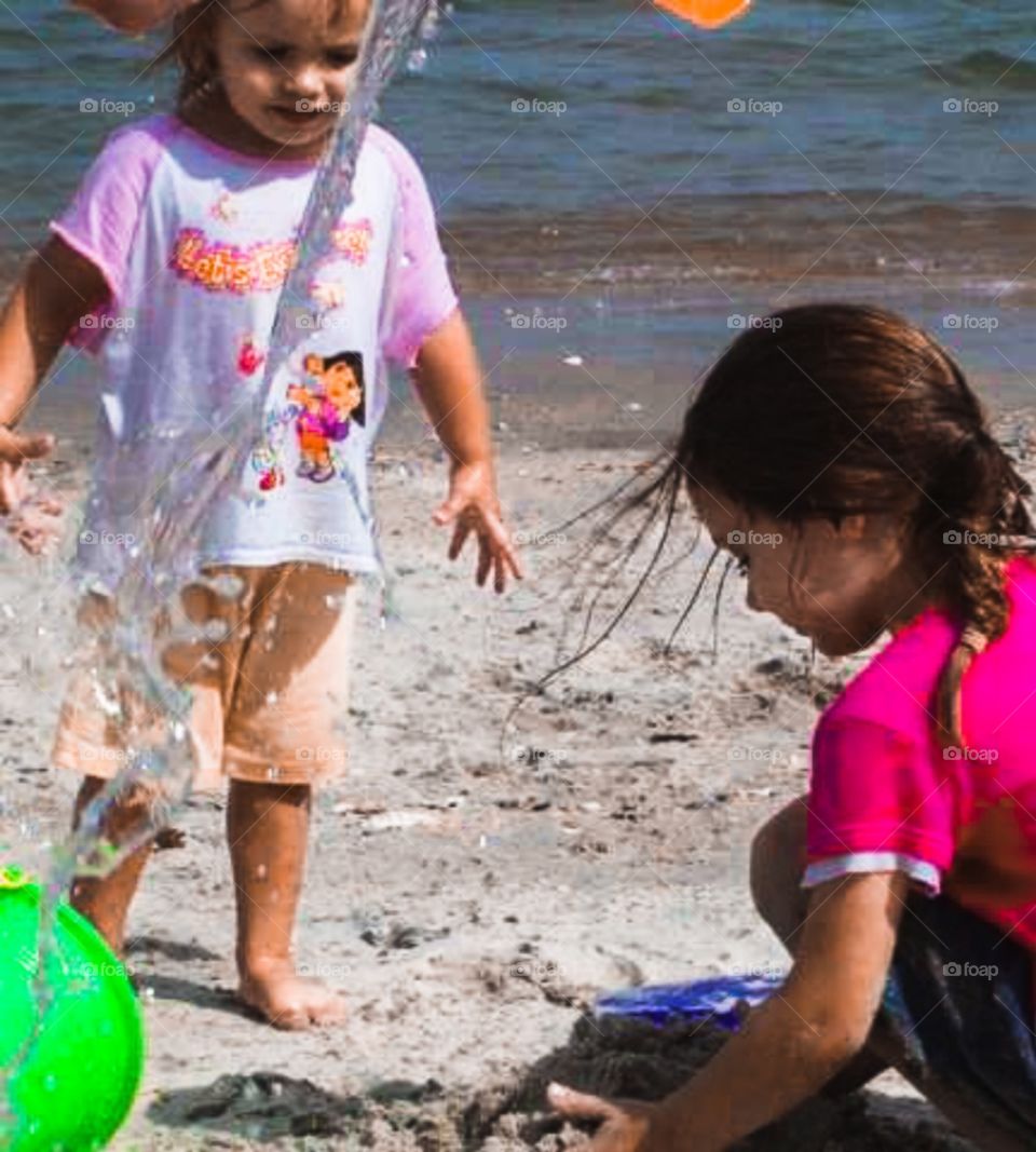 foap mission In Motion children playing on beach pouring water from bucket