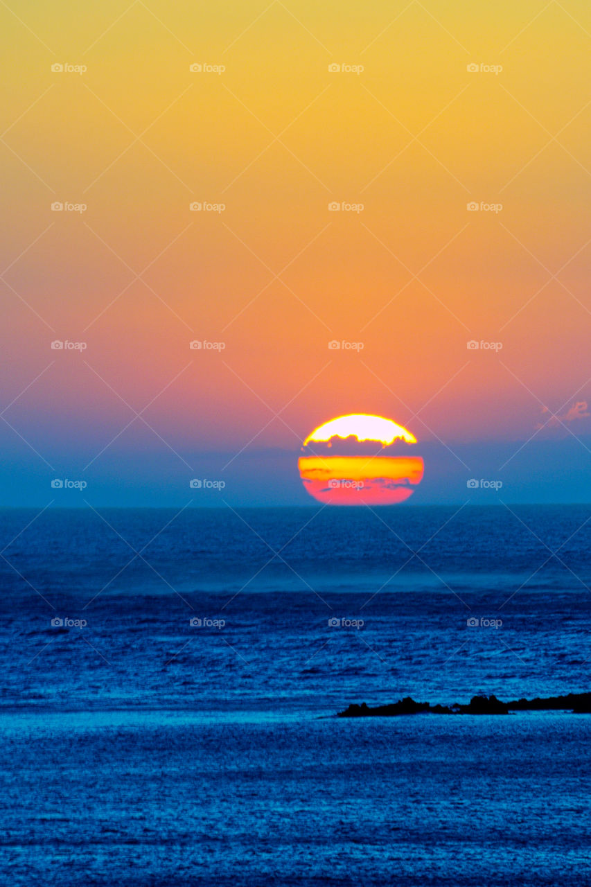 Fading of a summer day with the sun plunging into the sea with the splendid colors of the sunset.