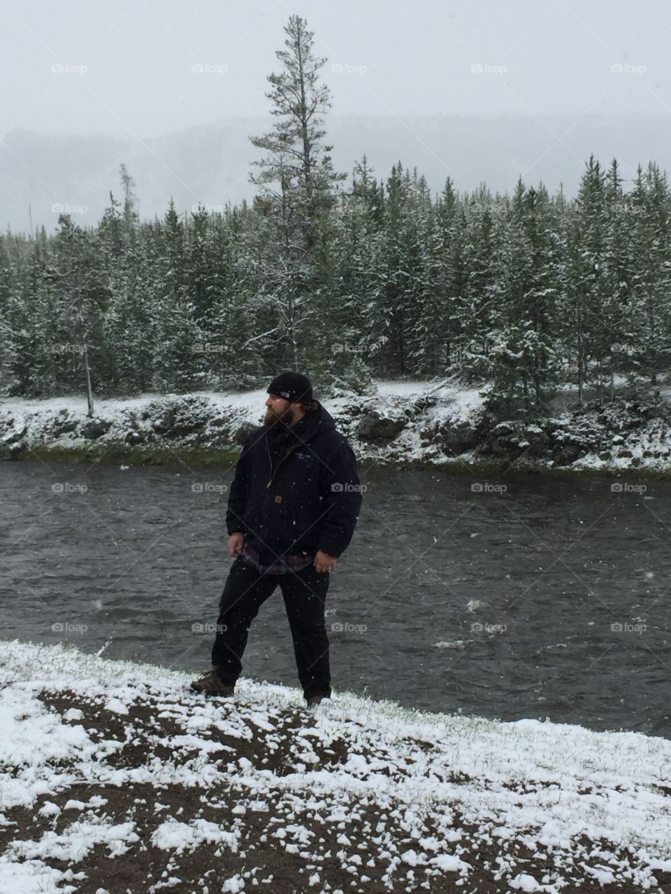 Man in snow by stream