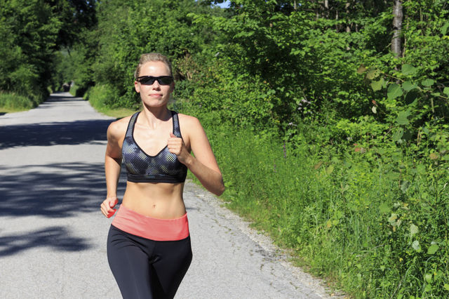 Woman jogging on road in the forest