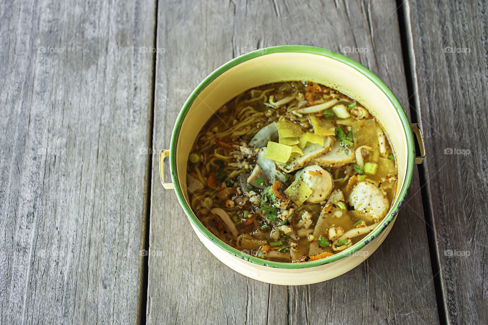 Spicy noodle soup with pork put the Pinto on wooden.