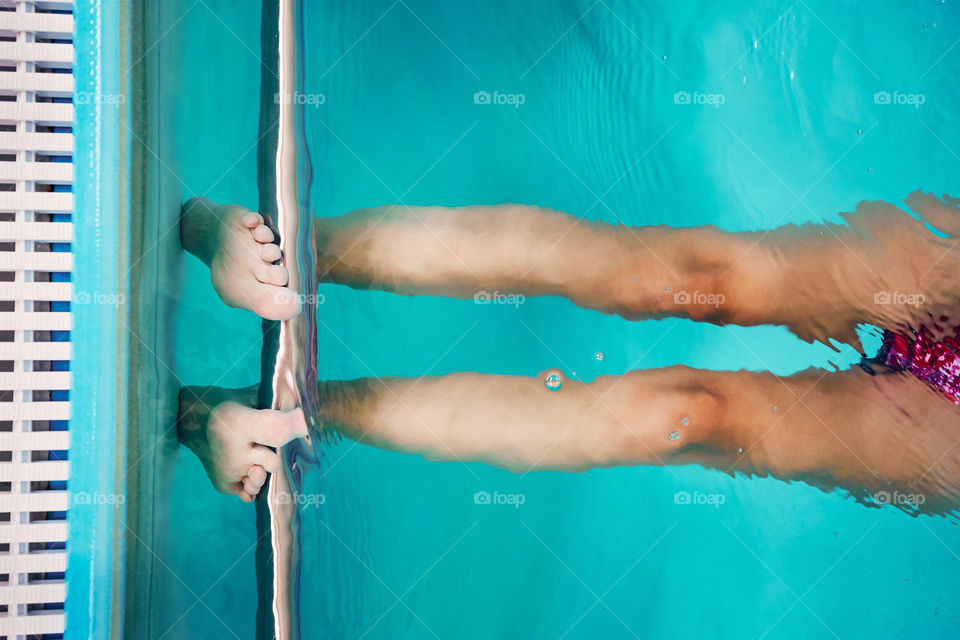 Young woman swimming and relaxing in swimming pool. Candid people, real moments, authentic situations