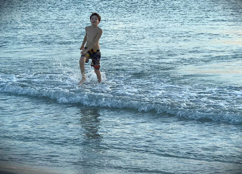 Boy frolicking in the waves.