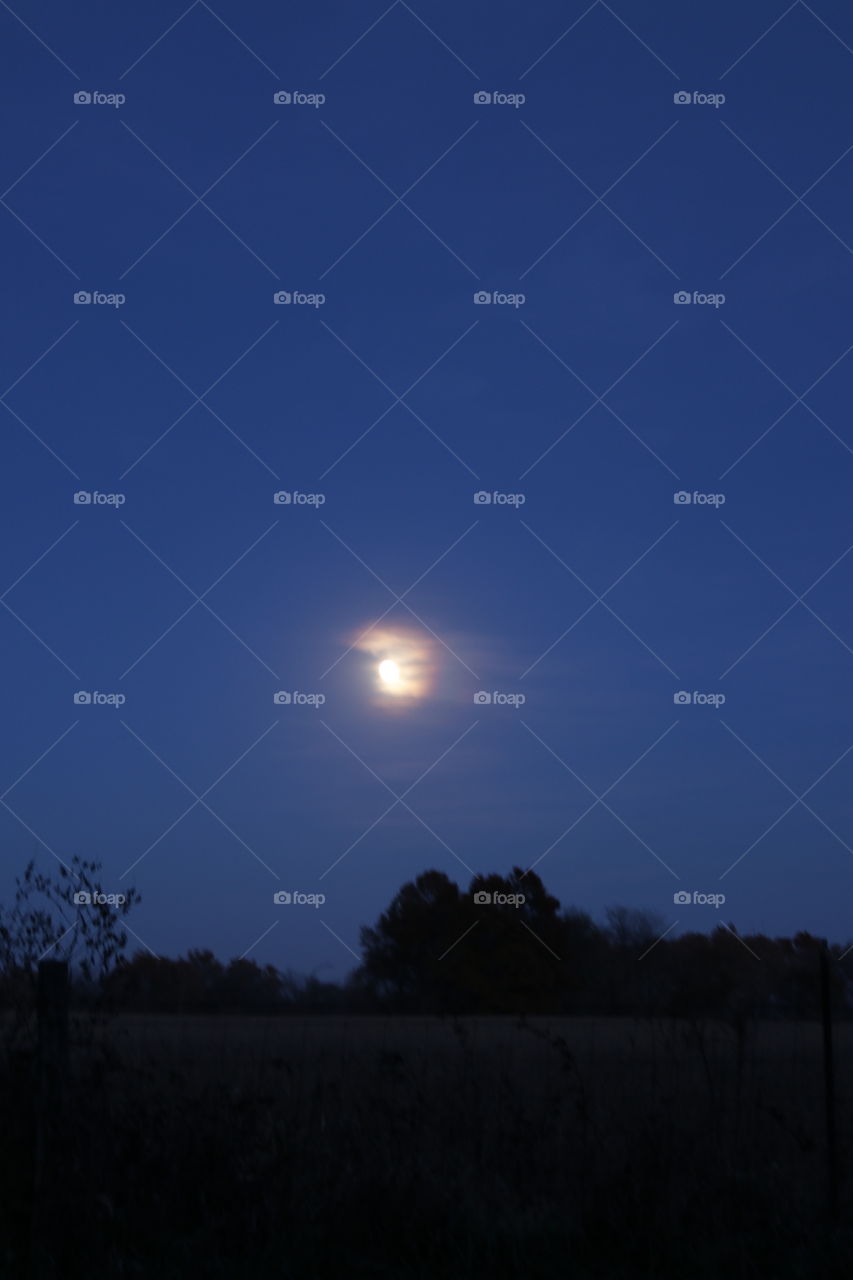 The moon peeking through a passing cloud.