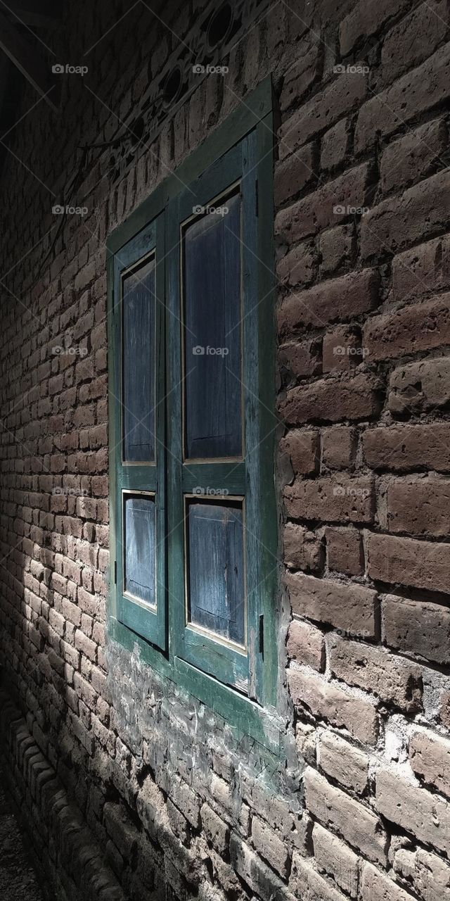 The window next to the house is simple. The windows are dark blue in the middle and dark green in the frame.