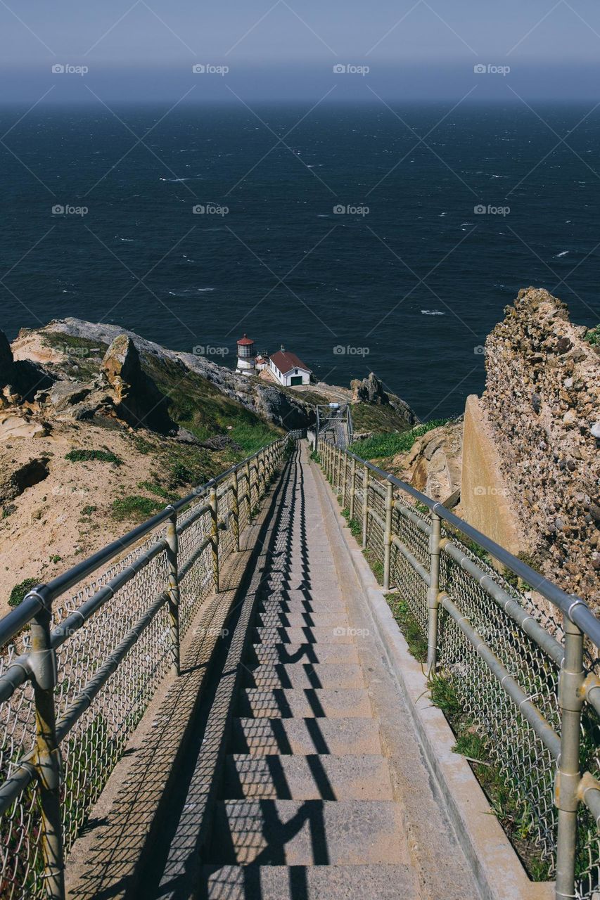 Walking Bridge To Lighthouse By Pacific Ocean