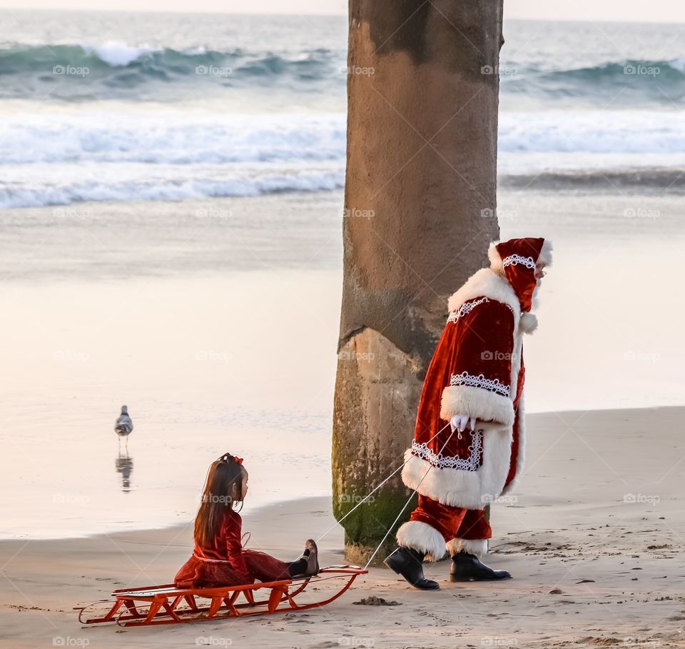 Santa pulling a child on a sled