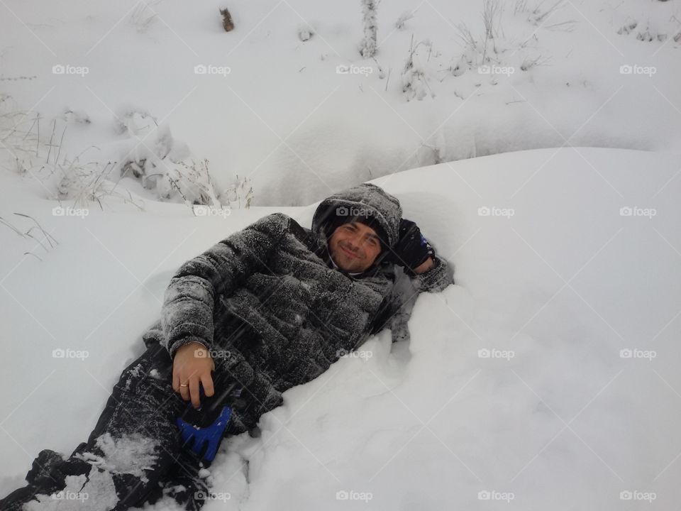 young man lying in the snow