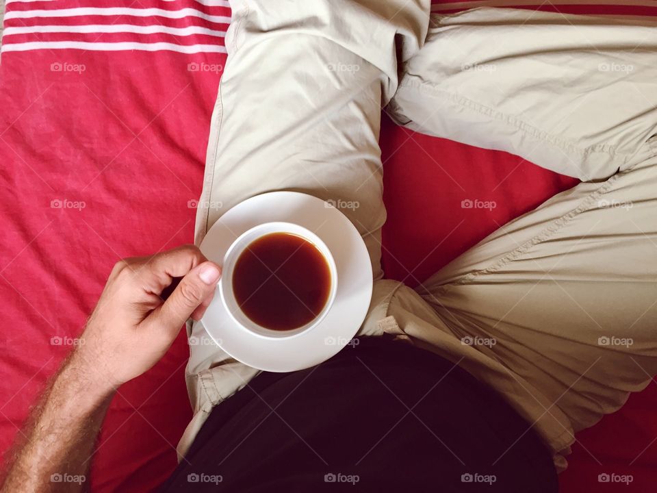 A man drinking coffee in the bathroom 