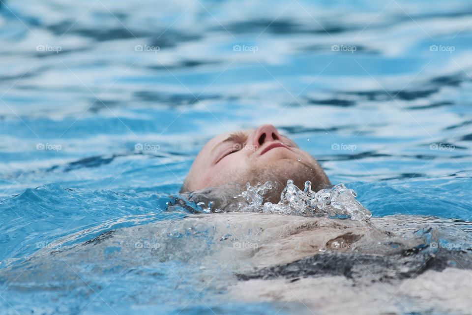 Young man swimming in pool 