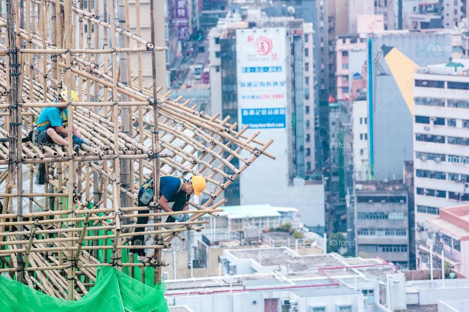 Bamboo scaffold builder working at heights