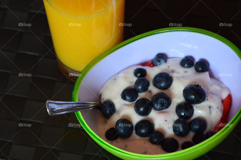 Healthy fruits breakfast full of vitamins with strawberry,  berries ,yogurt and orange juicy drink