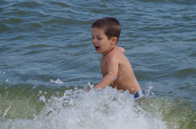 Cute boy splashing water in the sea