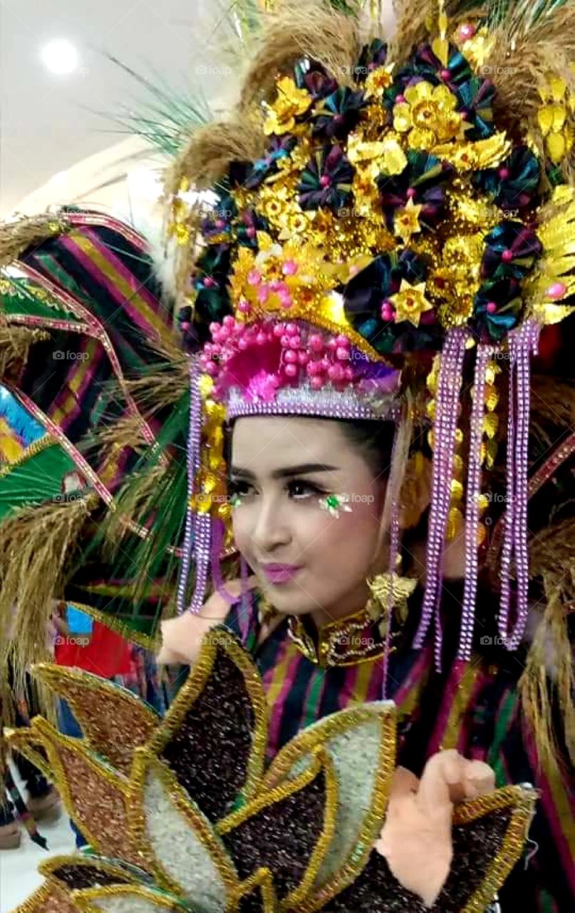 A beautiful woman wearing a unique and attractive costume is participating in the Fashion Carnaval in Jember, East Java,Indonesia