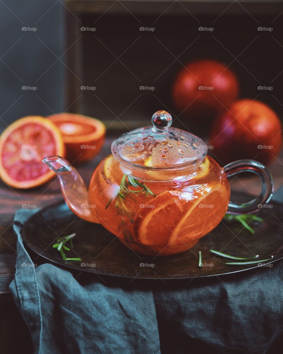 Blood oranges and rosemary tea in a glass kettle