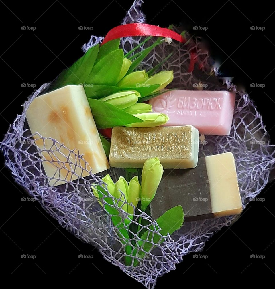 кучочки мыла с цветами ландыша на черном фоне