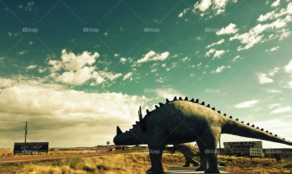 Painted desert. Dinosaur statue in foreground, desert in background