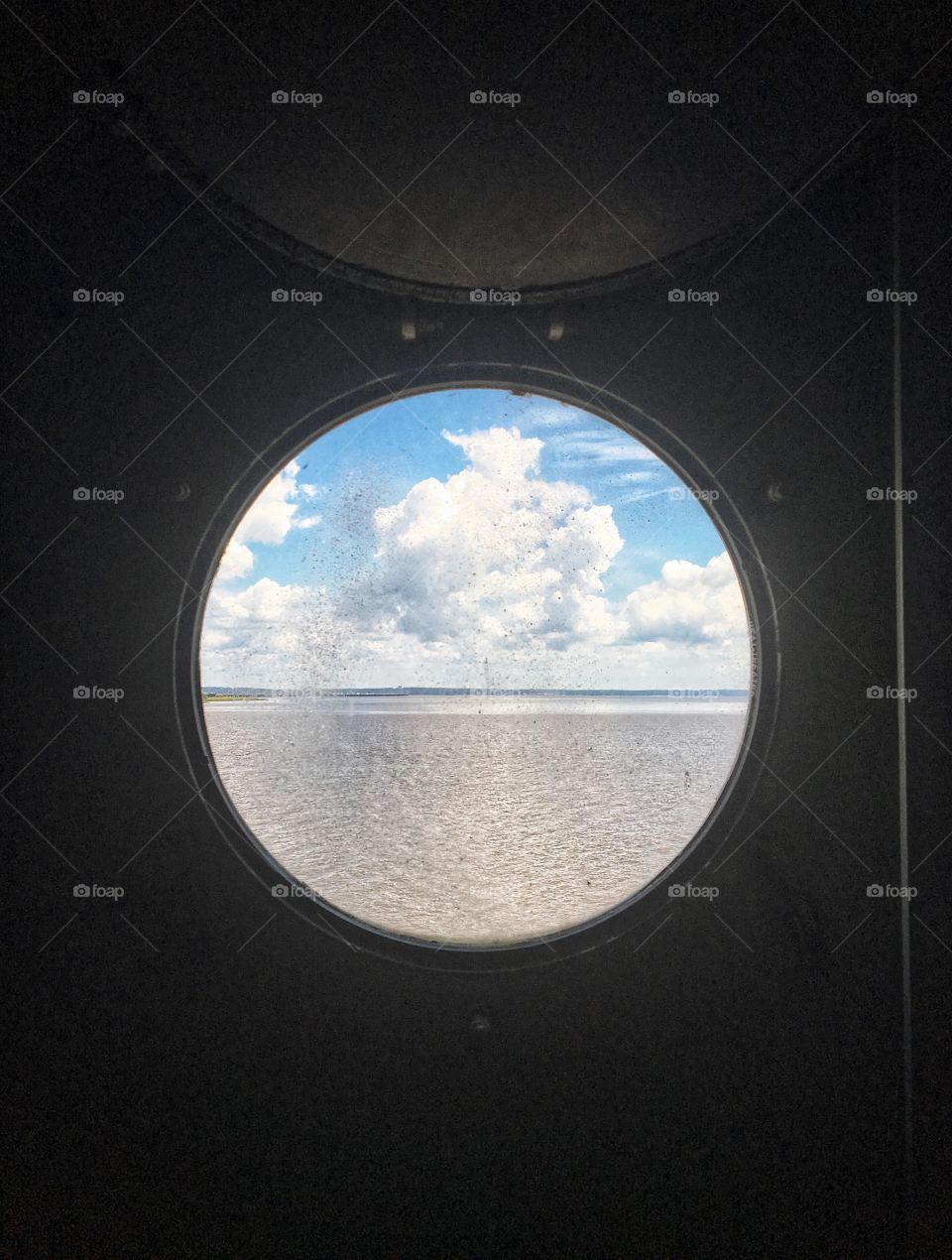 View of the Water and Sky from Porthole on a Battleship 