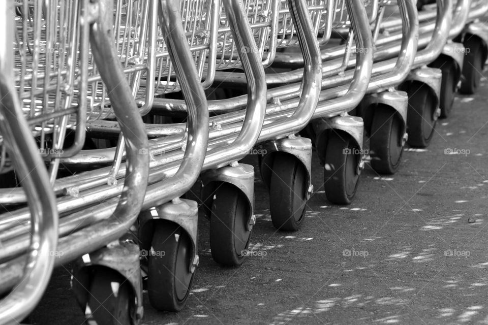 Multiple black and white groceries store trolley wheels in a row