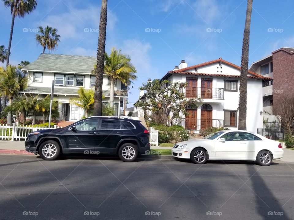 Beautiful  beach houses in Sunny Coastal California with cars in front of houses.
