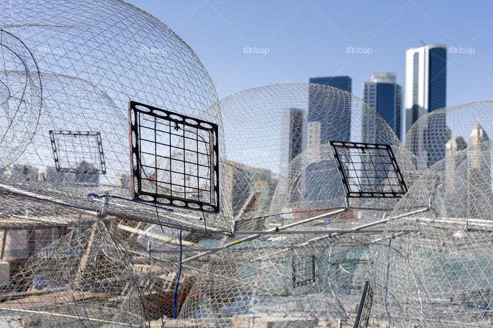 Metallic fishing nets against modern cityscape