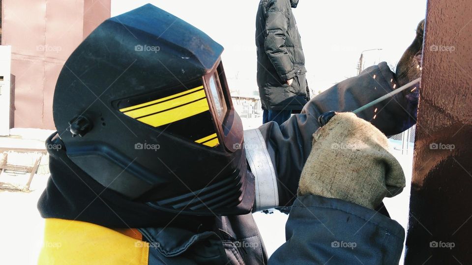 Welder work with metal construction overalls