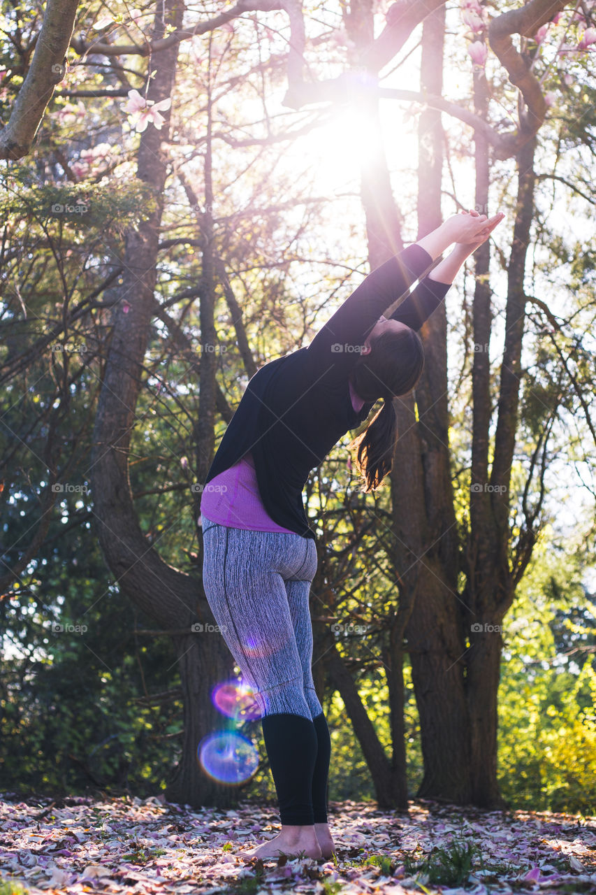 A woman Working out doing some yoga in the backyard 