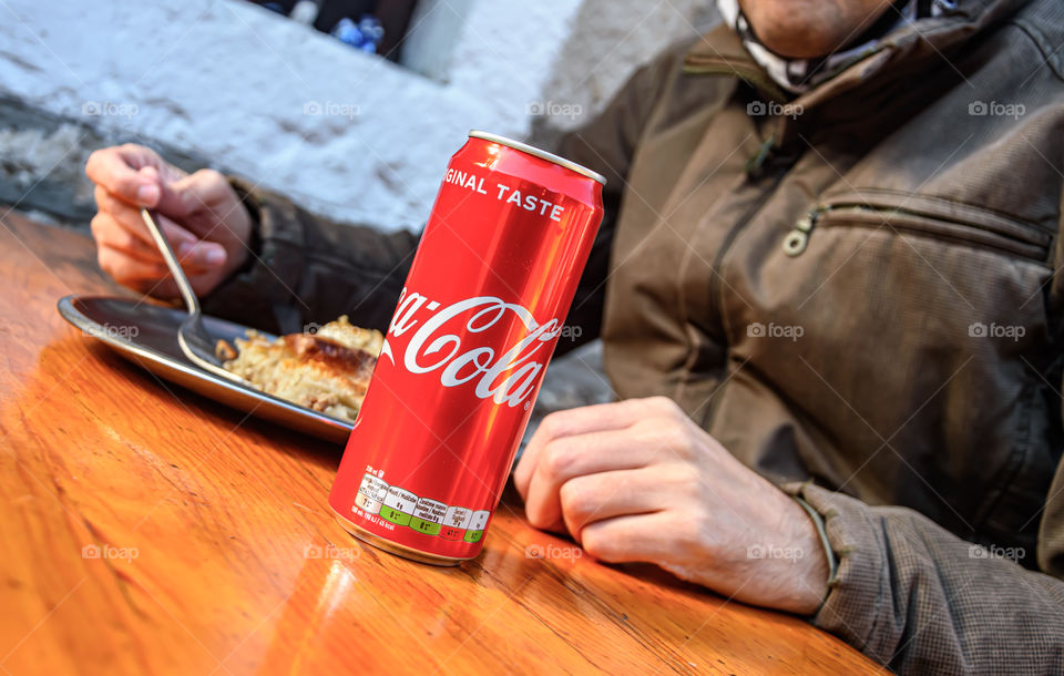 Man eating burek and drink Coca-Cola