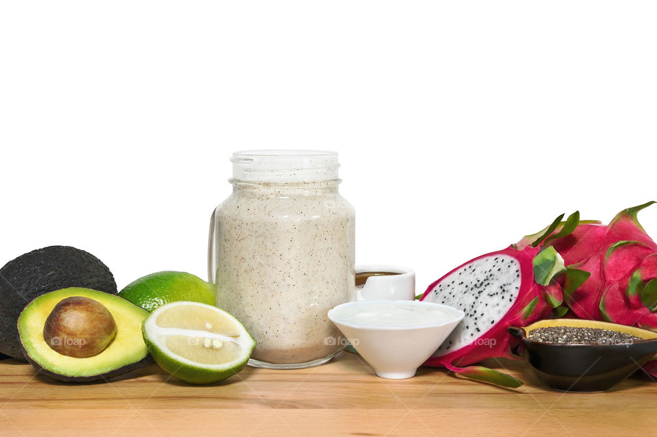 Energy smoothie in a mason jar with ingridientes on a wooden cutting board