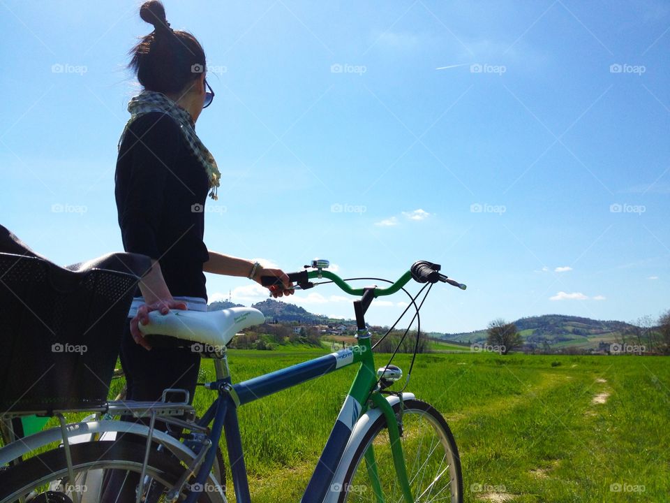 Woman and her bike in an open field. Woman and her bike in an open field