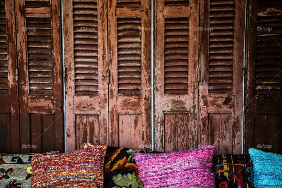 An old wooden doors with colorful pillows