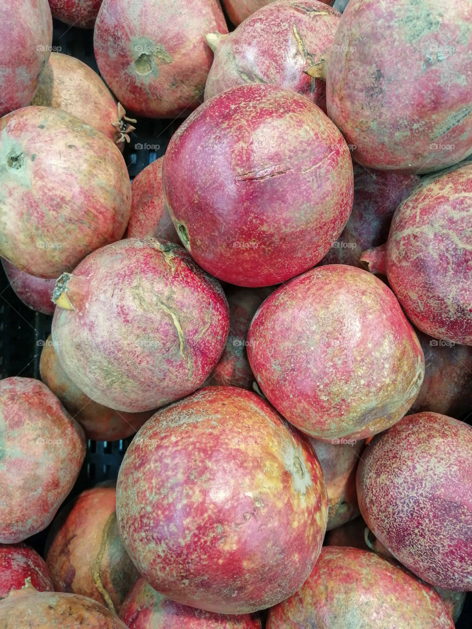 Bulk big pomegranates for sale in a grocery store