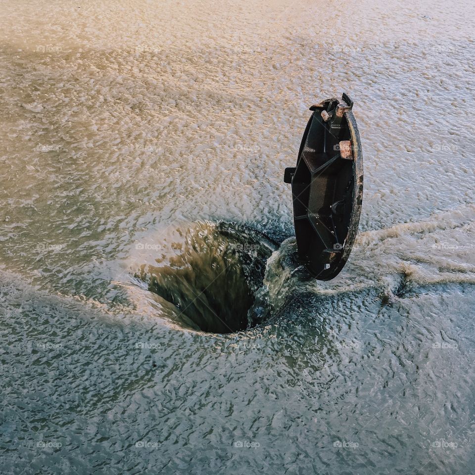 High angle view of flood flowing in manhole