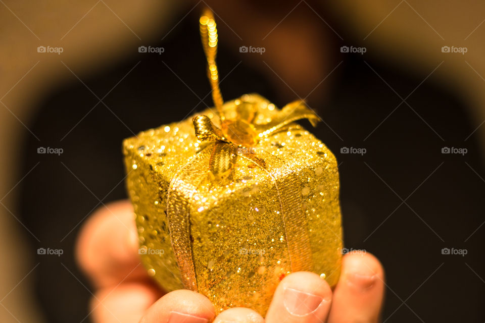 Hand holding golden giftbox