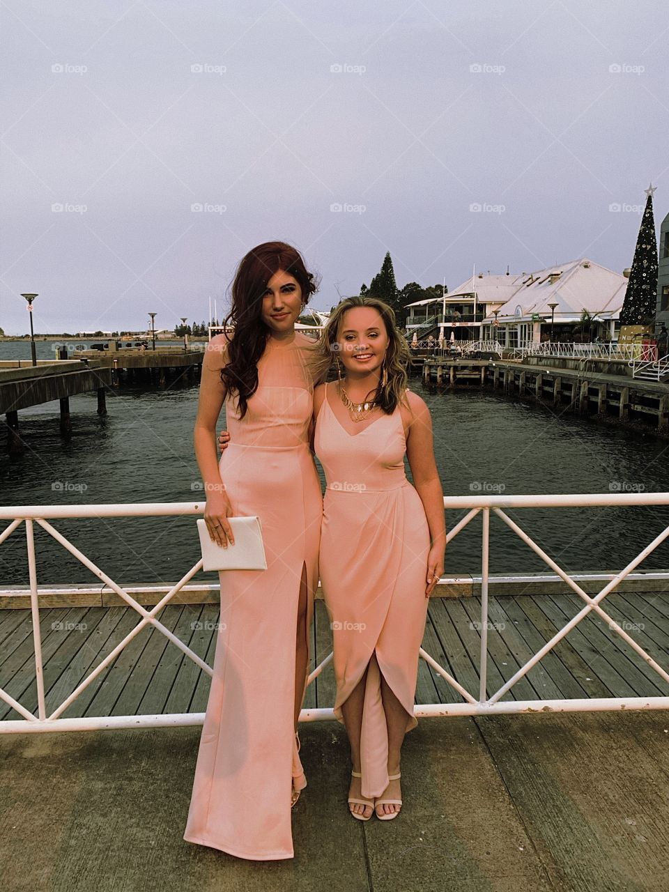 Two beautiful young adult women that are bestest of friends in matching pink dresses at a formal event in Australia NSW Newcastle on a lovely evening 😊