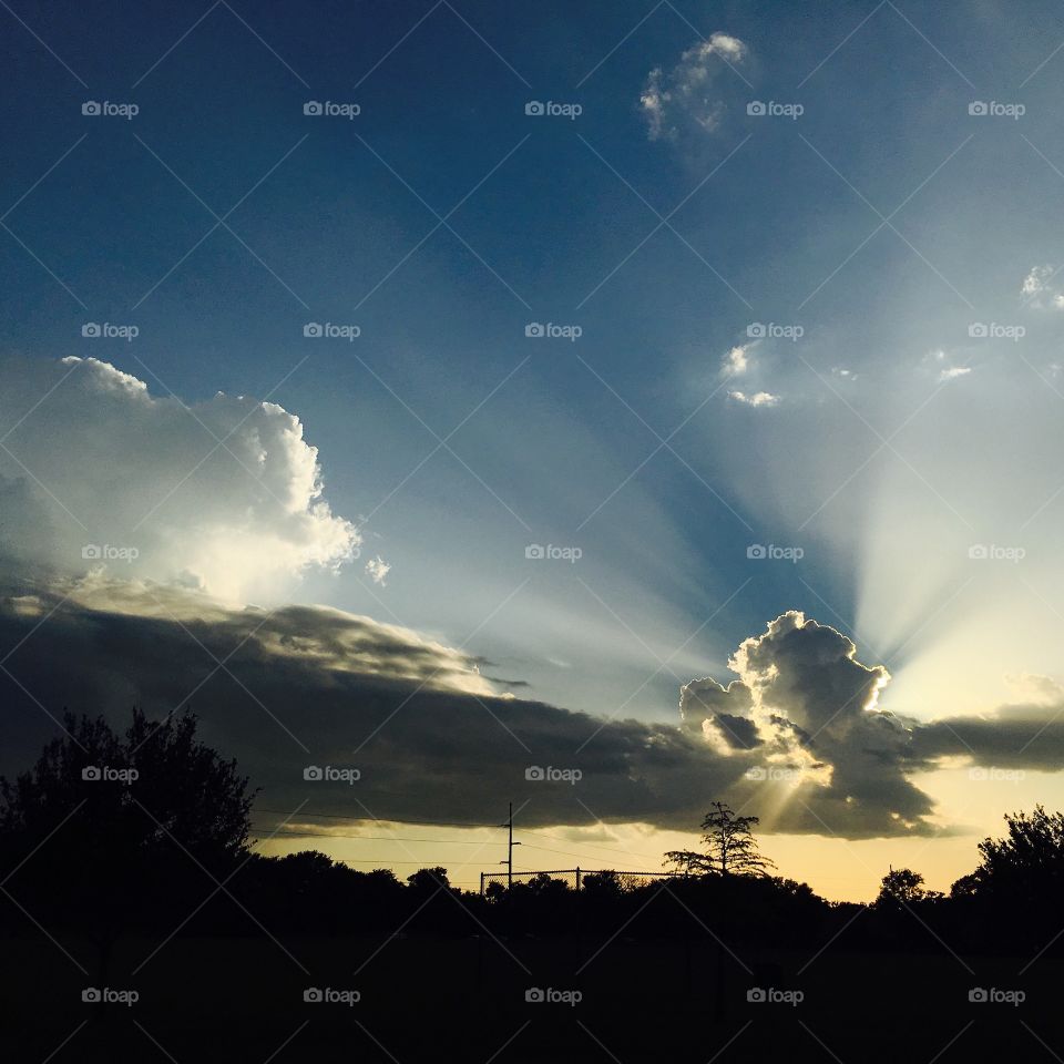 Sun rays through clouds over a park 