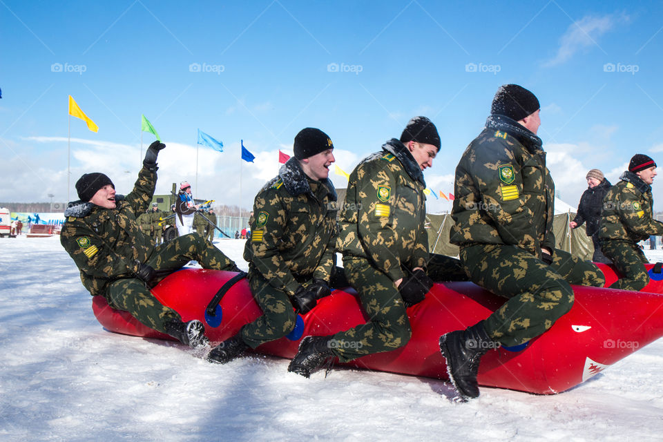 military cadets compete by jumping on an inflatable toy