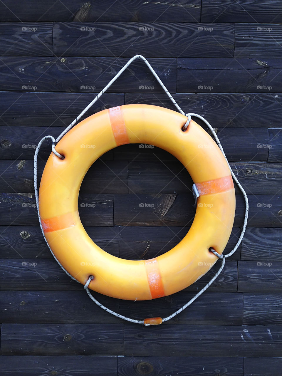 Orange lifebuoy on rustic wooden background 