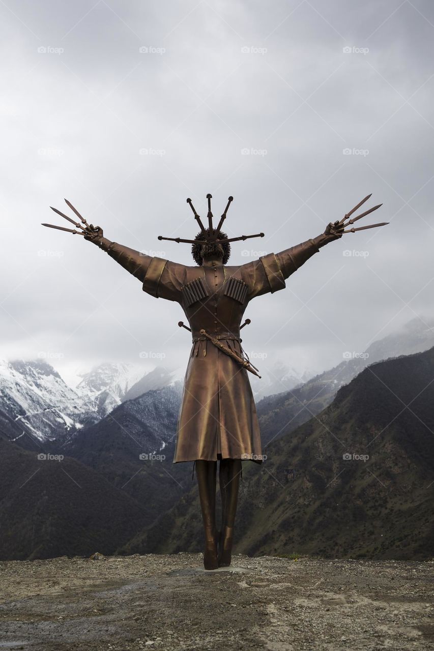 Dance With Daggers monument towering along with high mountain peaks in Verkhny Zgid village. North Ossetia