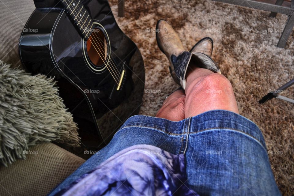 Country western music point of view woman in cowboy boots with guitar 