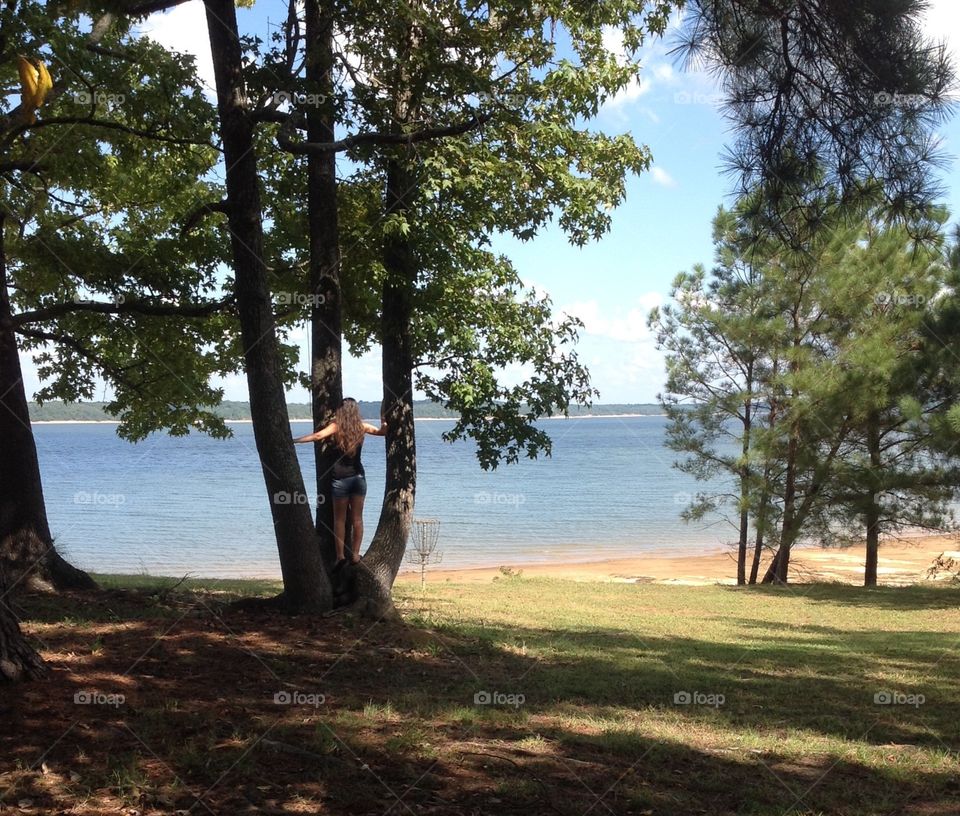 Girl in tree overlooking water