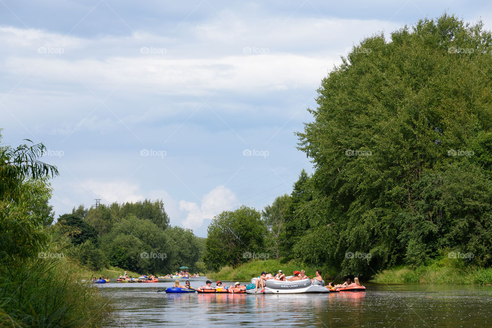 Helsinki, Finland – July 30, 2016: Unidentified people drafting and tubing in Vantaanjoki river on rubber dinghies, rafts and other inflatable floating devices at yearly Kaljakellunta (Beer Floating) festival which occurs at the end of the July or beginning of the August. Festival which usually attracts more than hundreds of participants every year is a spontaneous gathering of people and there is no official organizer for the event.