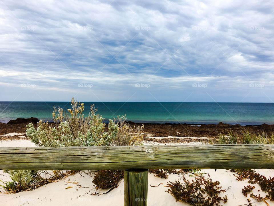 Stunning seascape, remote beach, with weathered wood fence foreground 