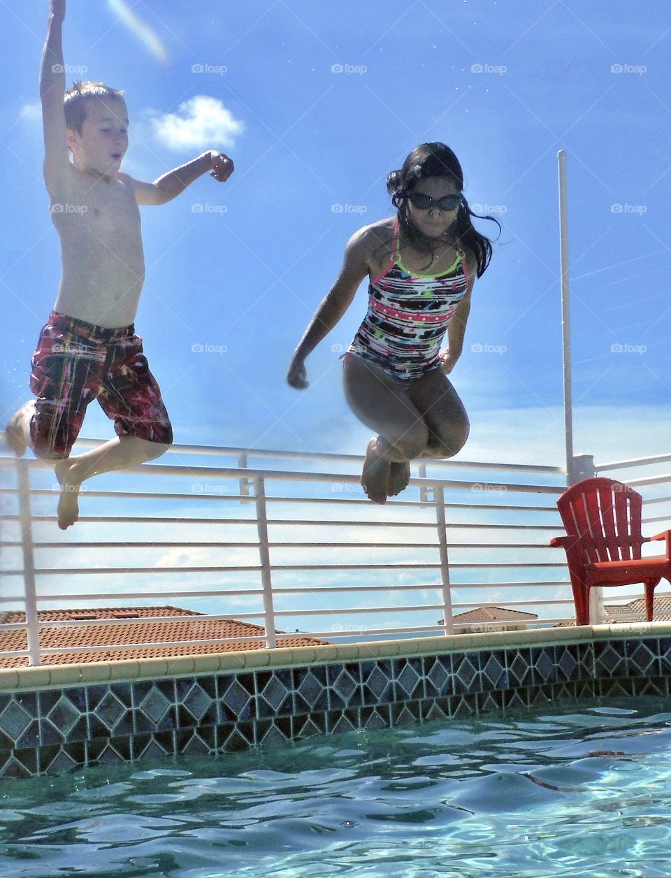 Happy children jumping into pool