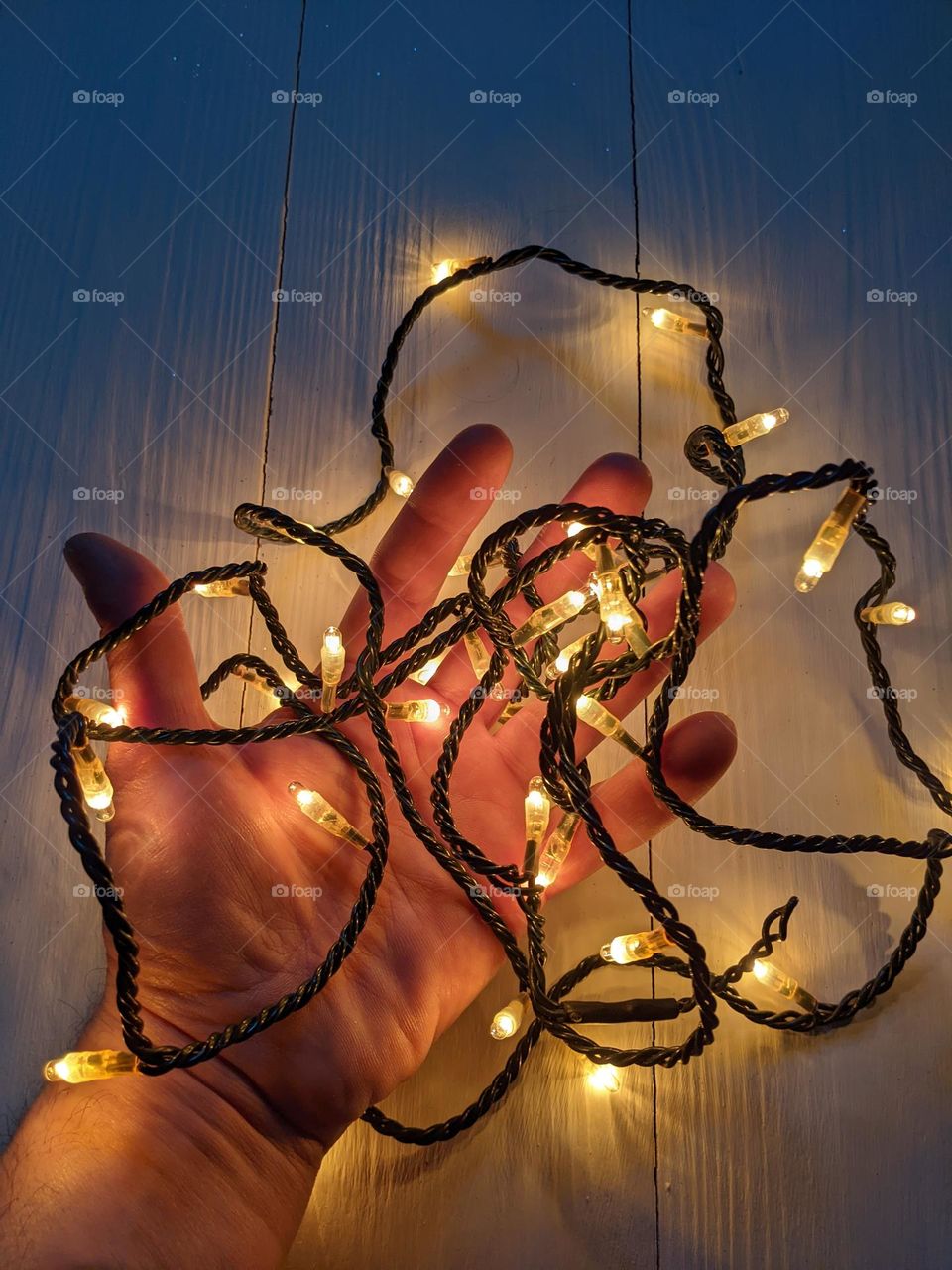male hand and glowing garland